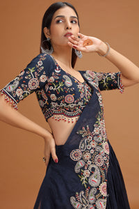 Woman wearing a Blue Lehenga Set with floral patterns against a brown background