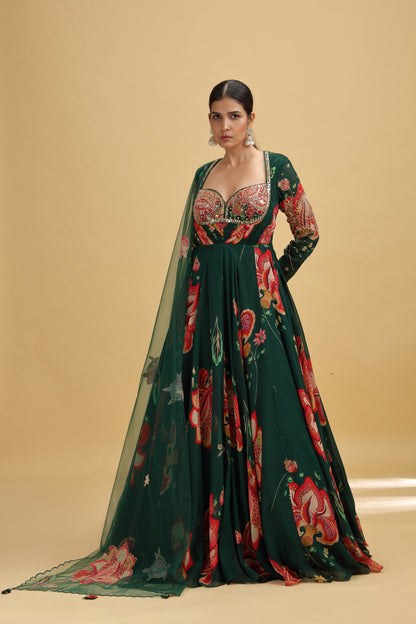 Woman wearing a dark green floral gown with a matching blouse on a beige background