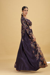 Woman wearing a dark blue embroidered salwar kameez on a beige background