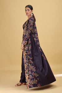 Woman wearing a long, dark blue floral dress on a beige background