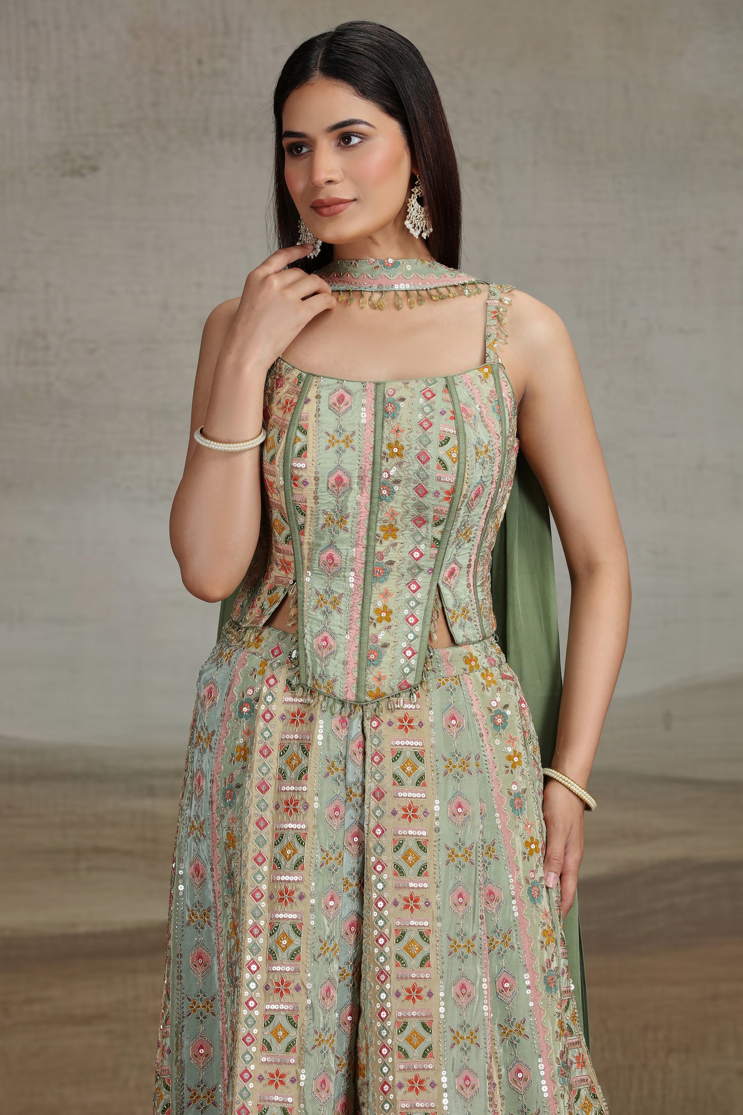 Woman wearing a patterned green dress with a neutral background