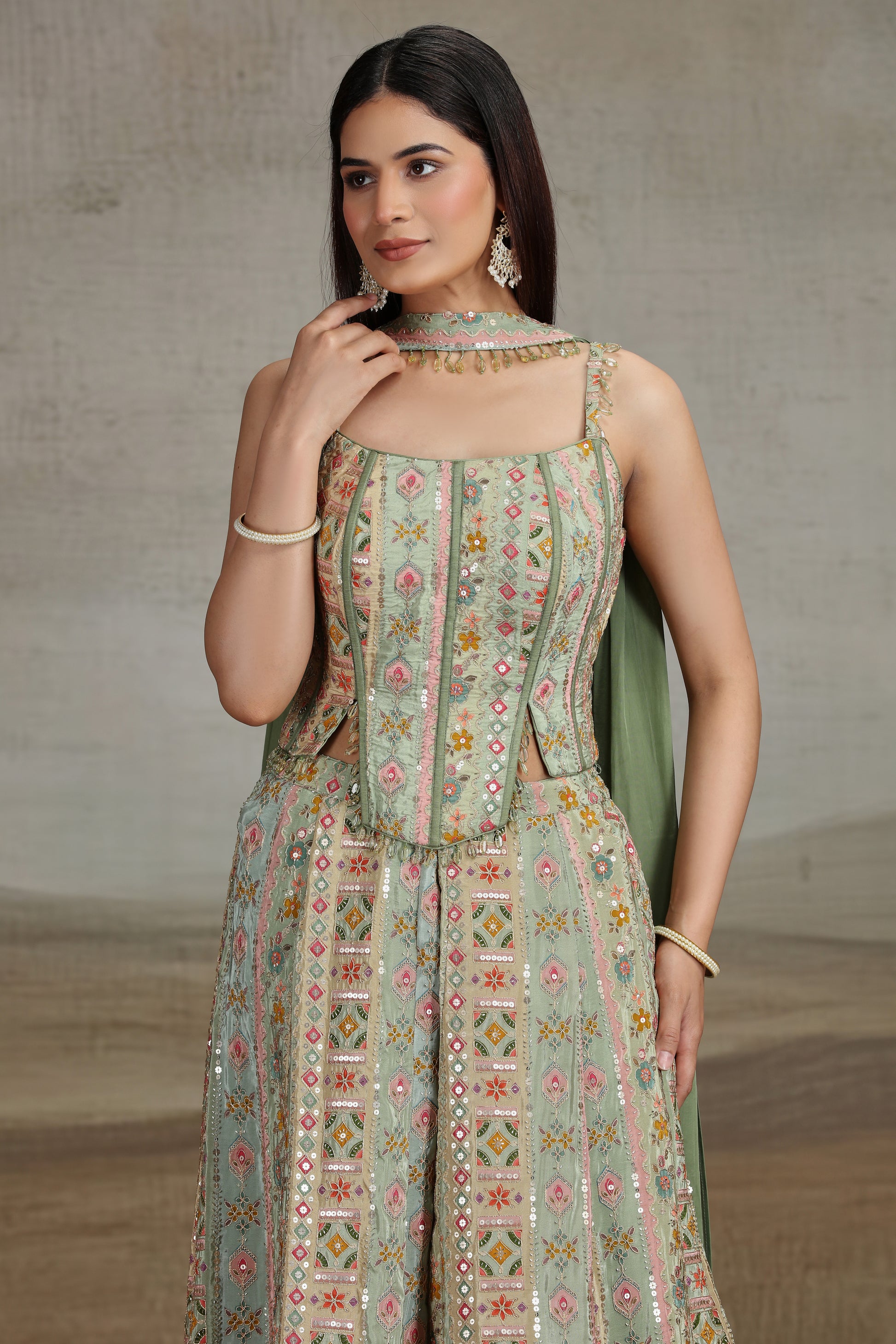 Woman wearing a patterned green dress with a neutral background