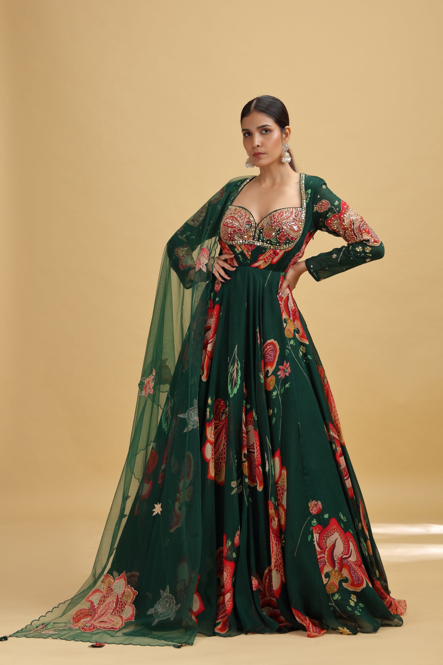 Woman wearing a green floral gown with mirror work