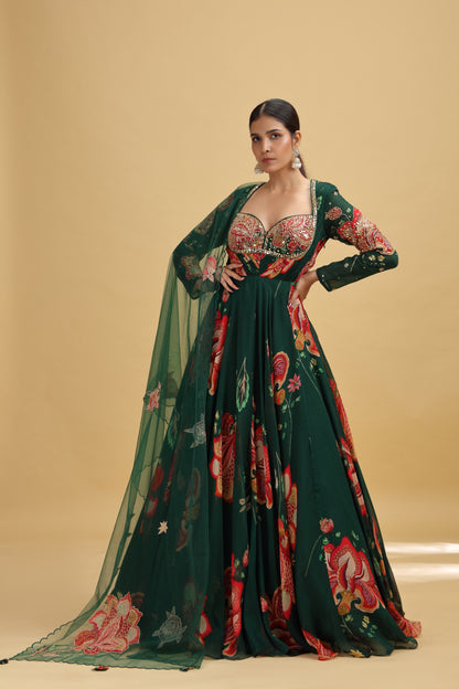 Woman wearing a green floral gown with mirror work