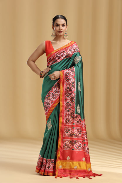 Woman wearing a green and red saree with a beige background