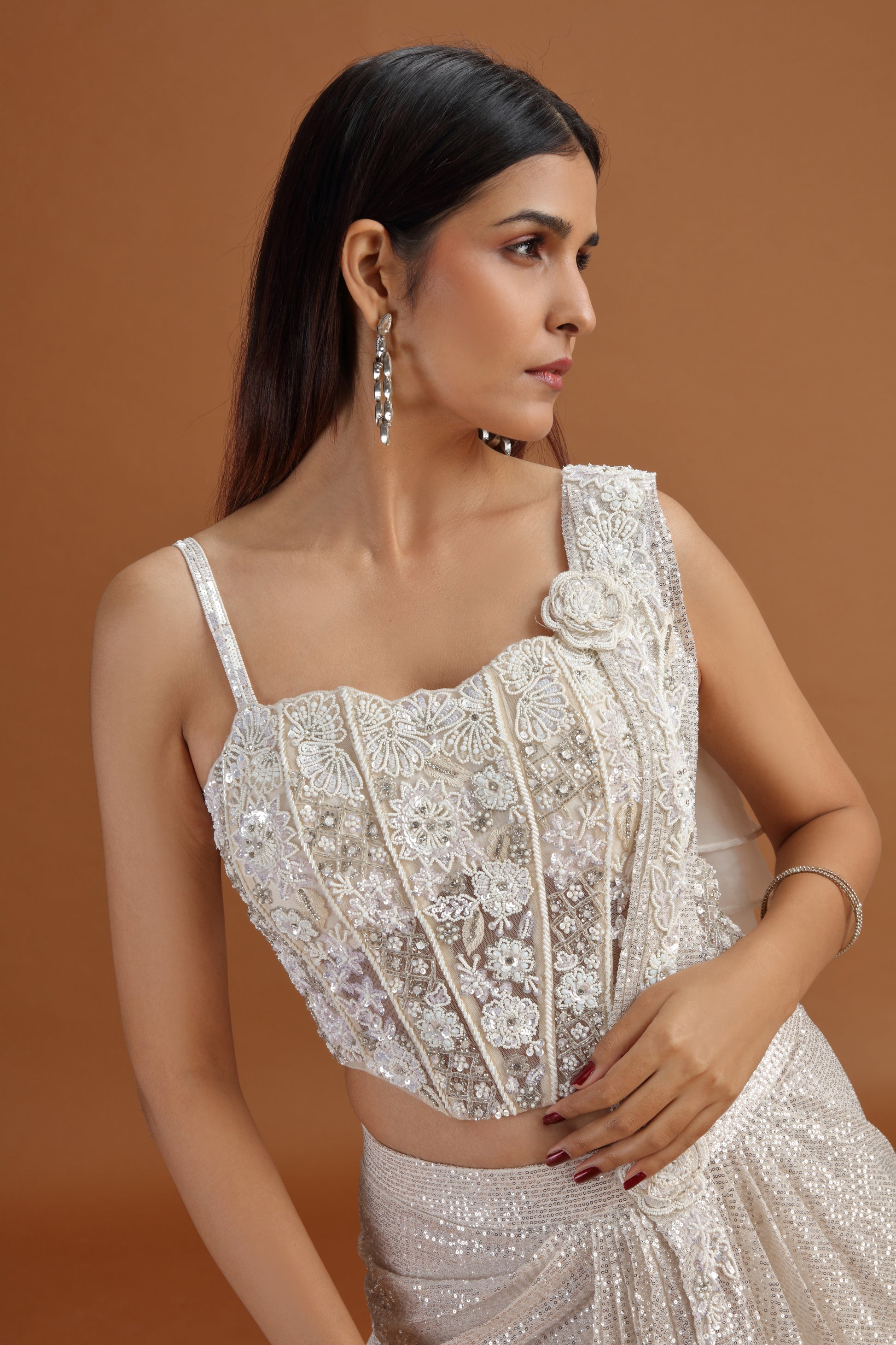 Woman wearing a white embroidered saree with stitched net blouse & french knots