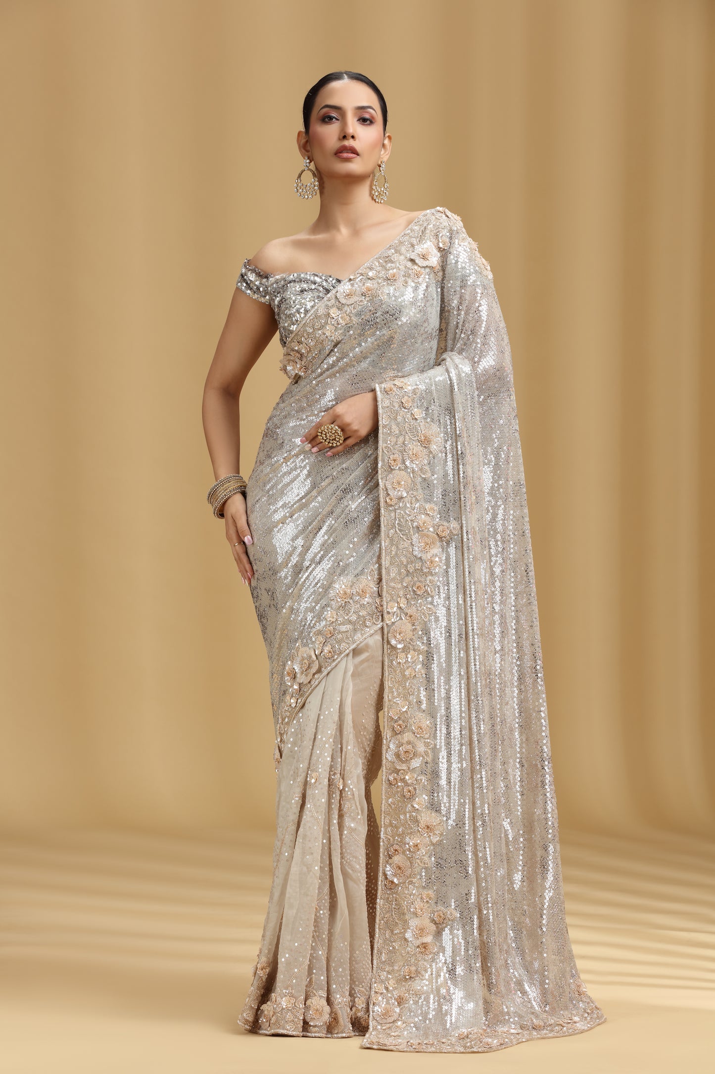 Woman wearing a Ivory Organza Saree with floral patterns on a beige background