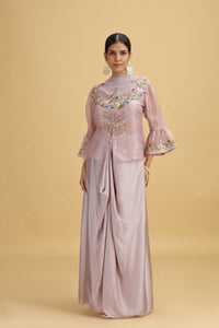 Woman wearing a lilac satin suit with an embroidered top
