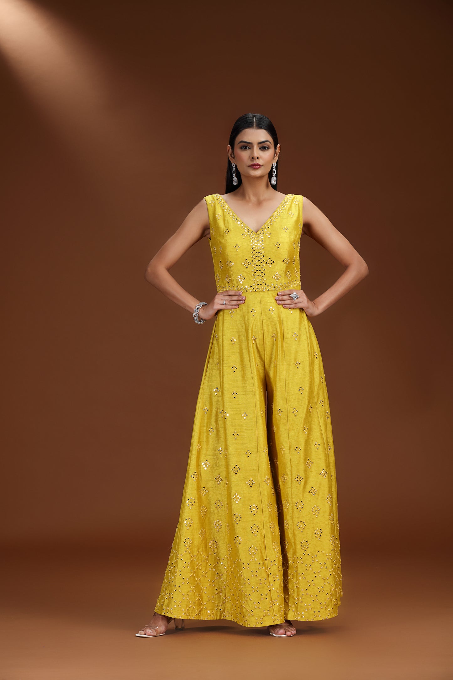 Woman wearing a lime green embroidered salwar kameez against a brown background