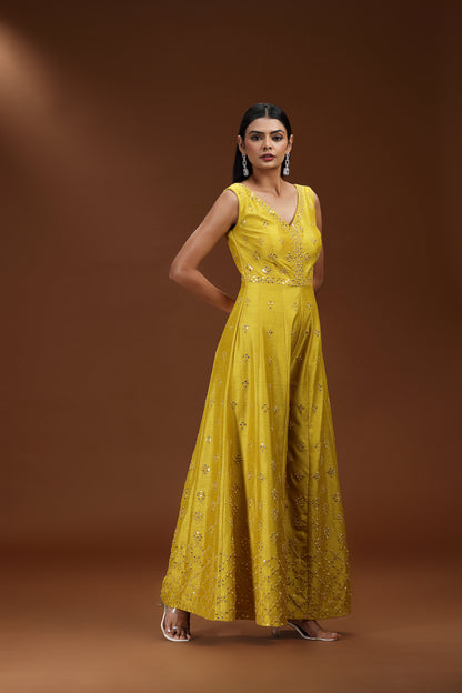 Woman wearing a yellow dress with intricate detailing on a brown background