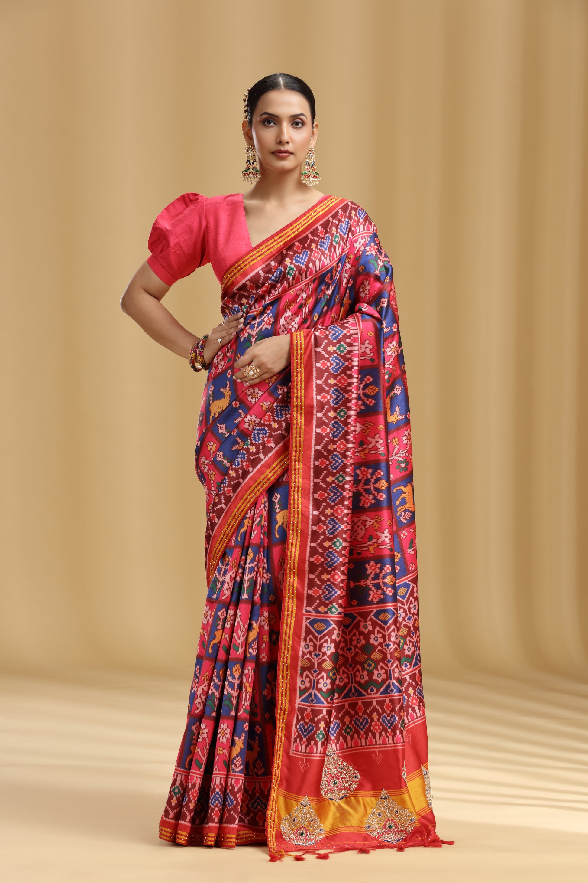 Woman wearing a colorful chanderi saree with a pink blouse against a beige background