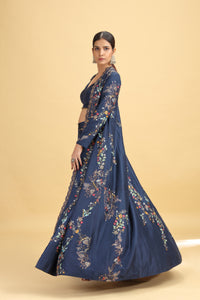 Woman wearing a navy blue embroidered traditional outfit on a beige background