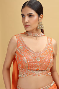 Woman wearing an orange embroidered blouse with a beige background
