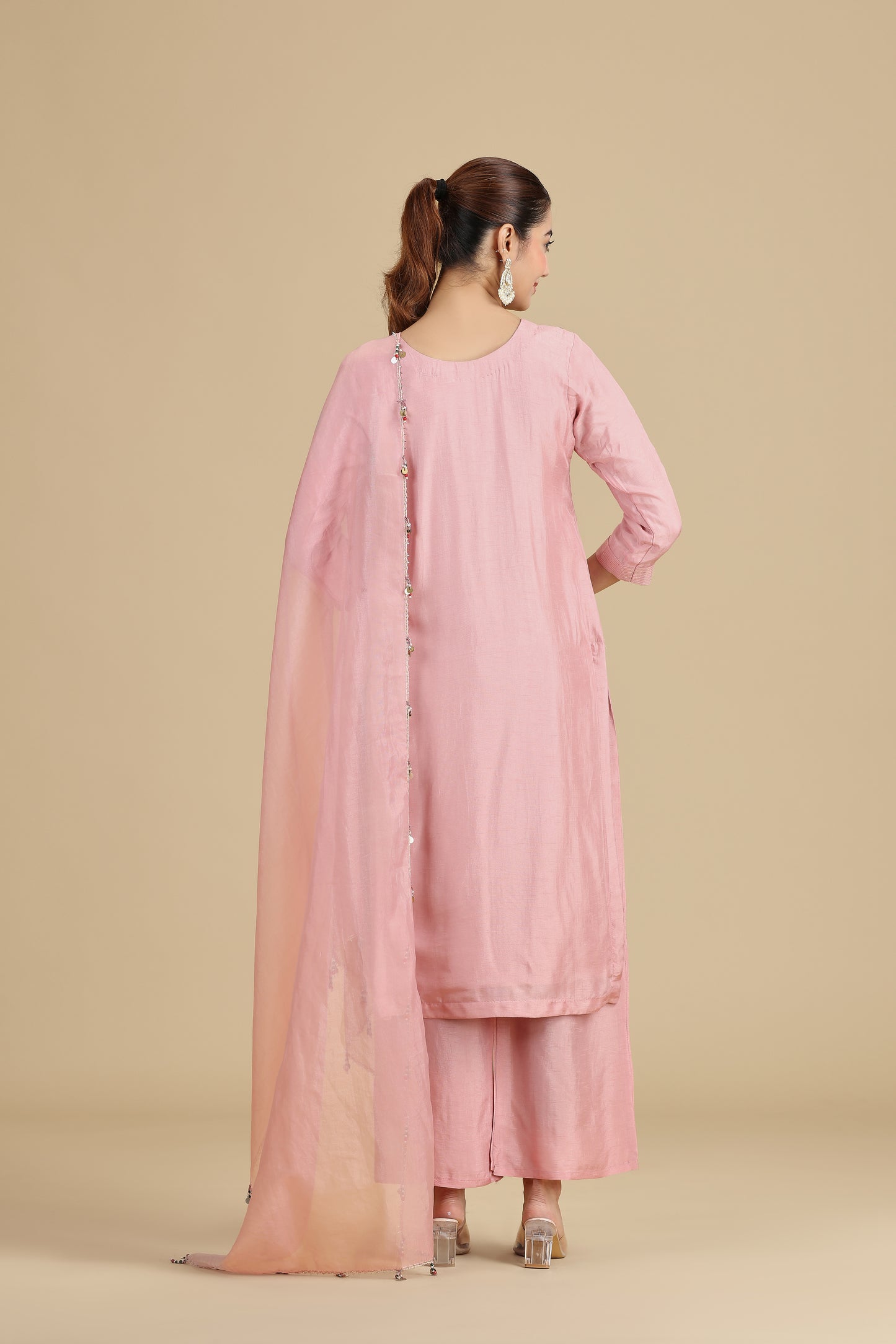 Woman wearing a peach traditional outfit on a beige background
