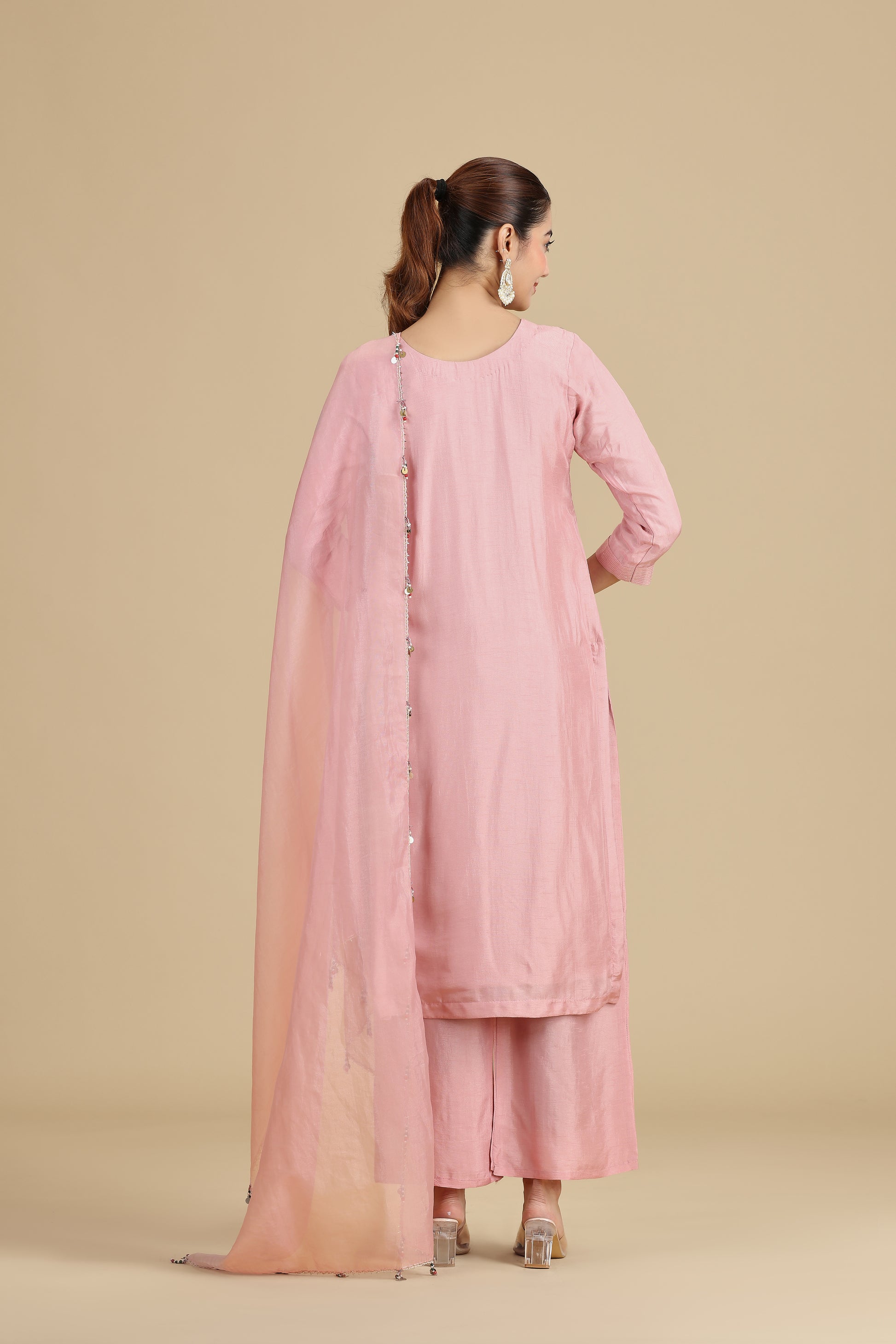 Woman wearing a peach traditional outfit on a beige background