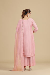 Woman wearing a peach traditional outfit on a beige background
