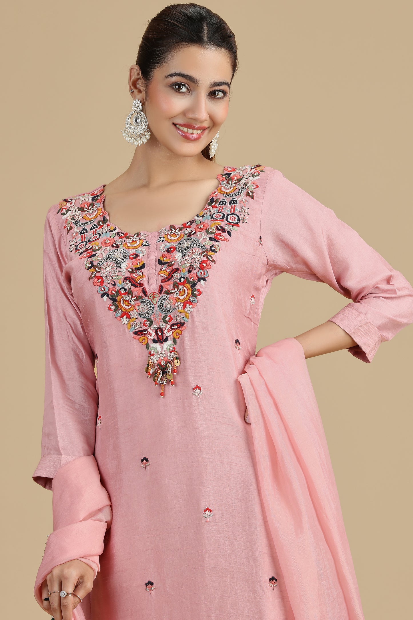 Woman wearing a peach kurta set traditional outfit on a beige background