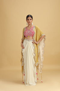 Woman wearing a traditional outfit with a yellow dupatta and pink blouse on a beige background