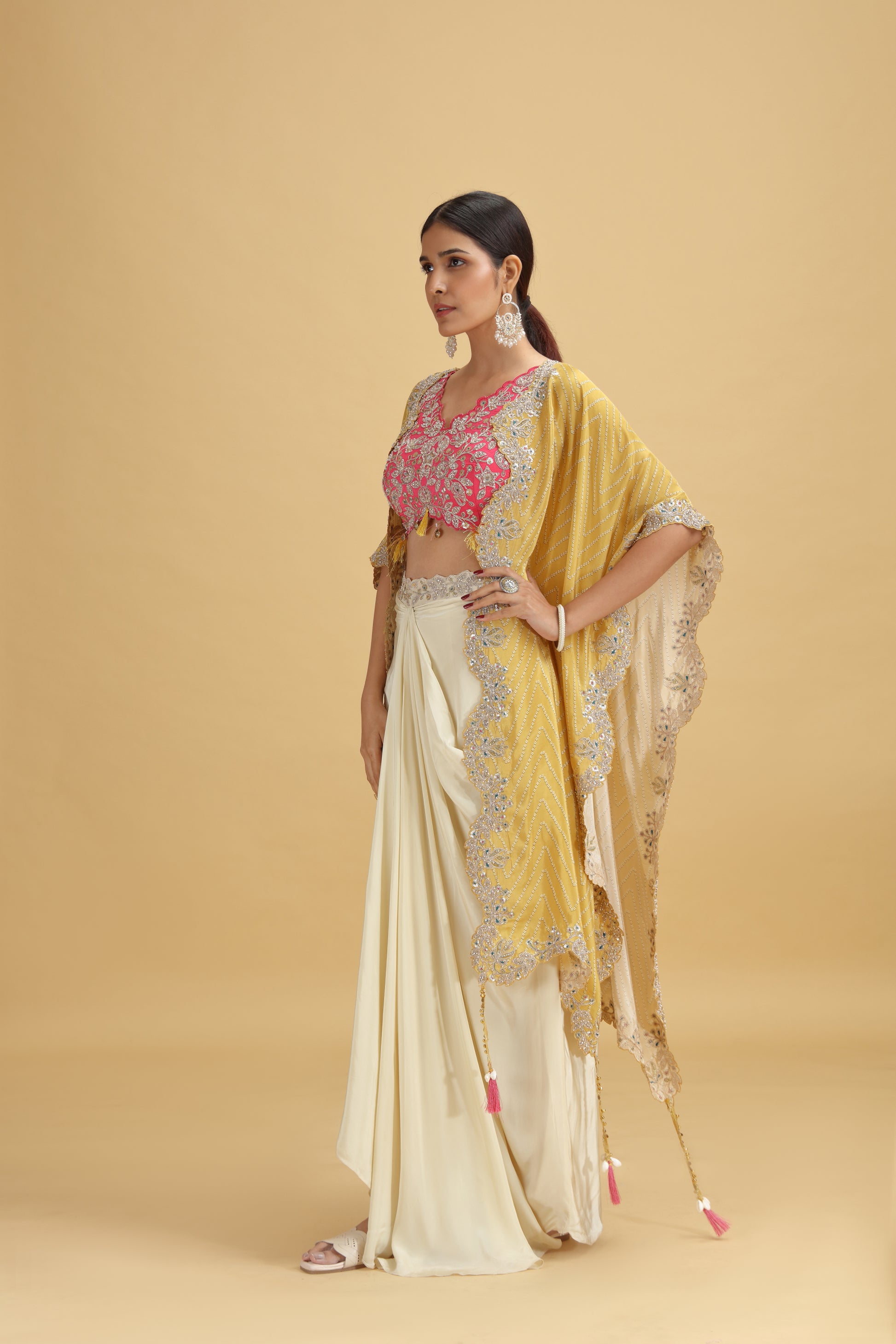 Woman wearing a salwar kameez with a yellow dupatta on a beige background