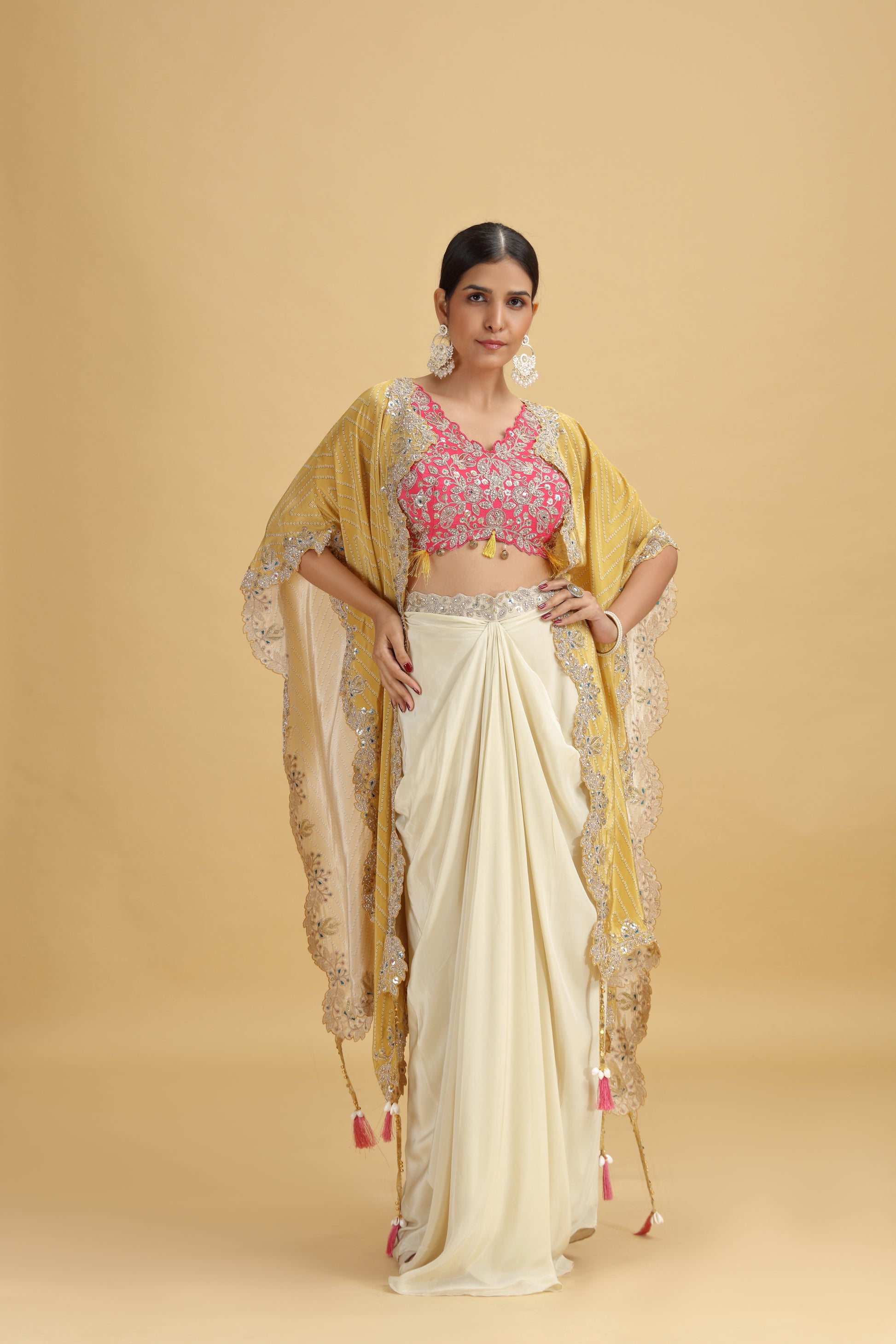 Woman wearing a traditional outfit with a yellow dupatta and pink suit on a beige background