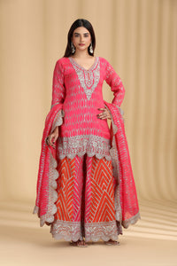 Woman wearing a pink georgette salwar kameez with sequins and zari embroidery