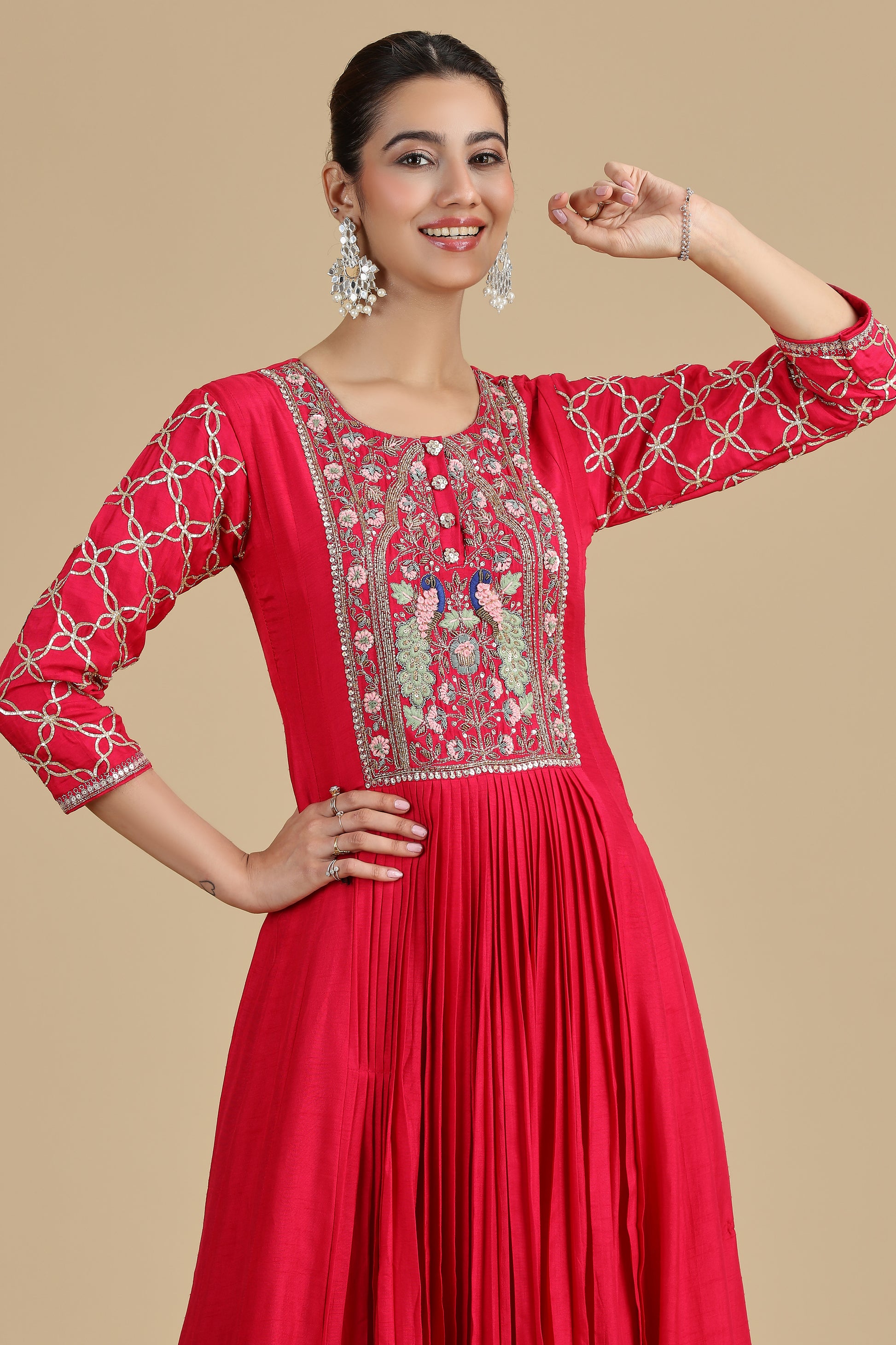 Pink traditional outfit with intricate embroidery on a beige background
