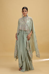 Woman wearing a pista green salwar kameez outfit with floral patterns on a beige background