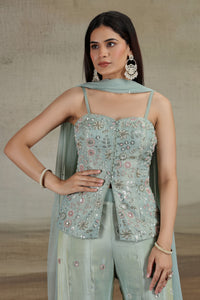Woman wearing a pista green embroidered top and matching dupatta against a neutral background