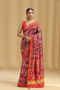 Woman wearing a vibrant saree with a geometric pattern on a beige background