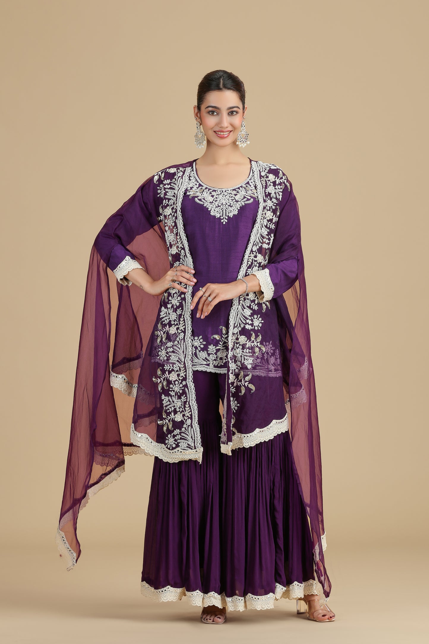 Woman wearing a purple traditional outfit with white embroidery on a beige background