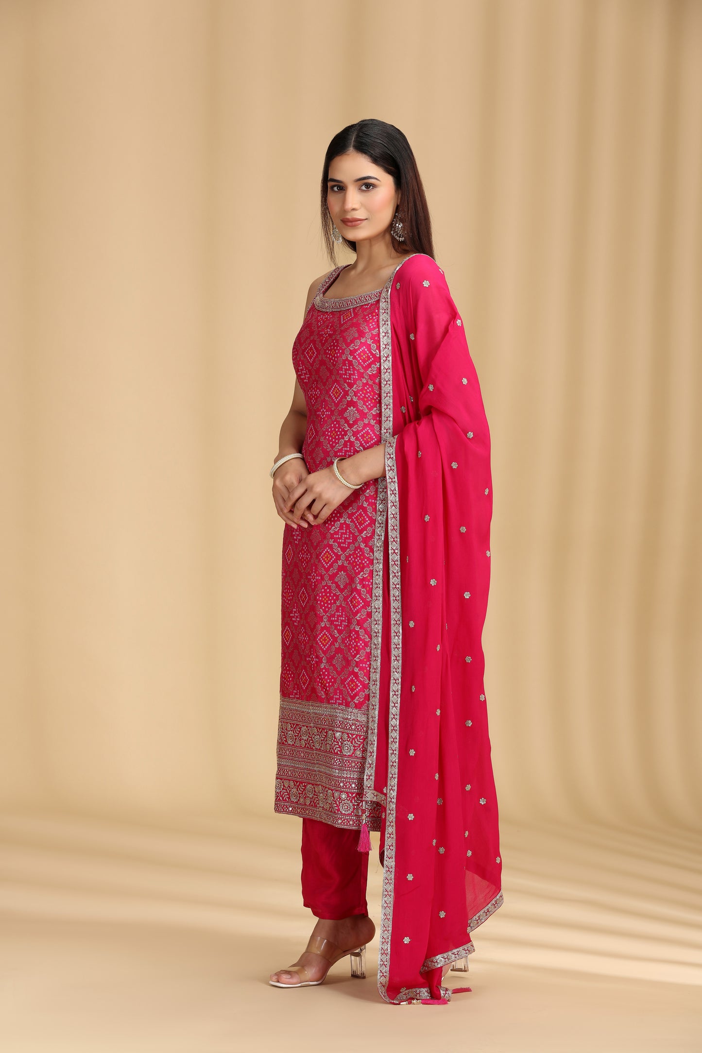 Woman wearing a rani pink banarasi silk salwar suit with sequins and zari work