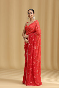 Woman wearing a red Ombre saree with a beige background