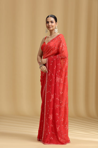 Woman wearing a red Ombre saree with a beige background