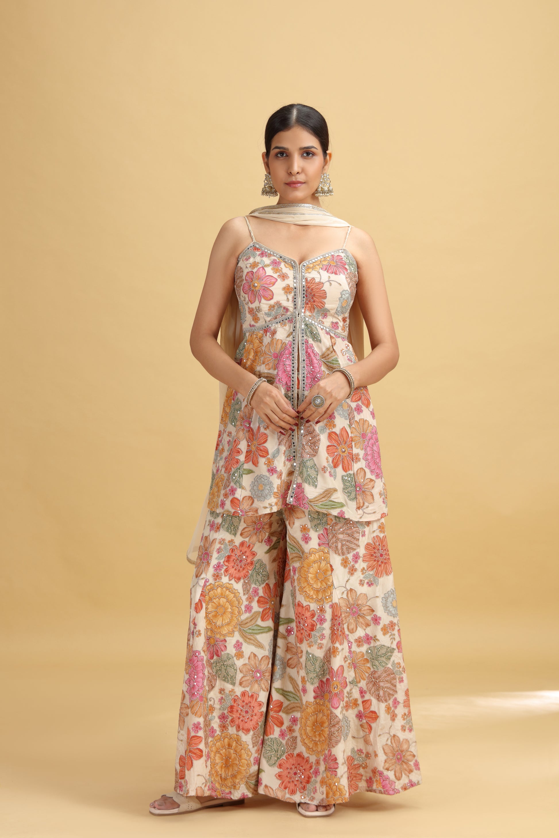 Woman wearing a floral jumpsuit on a beige background