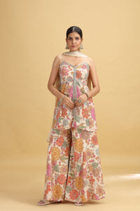 Woman wearing a floral jumpsuit on a beige background