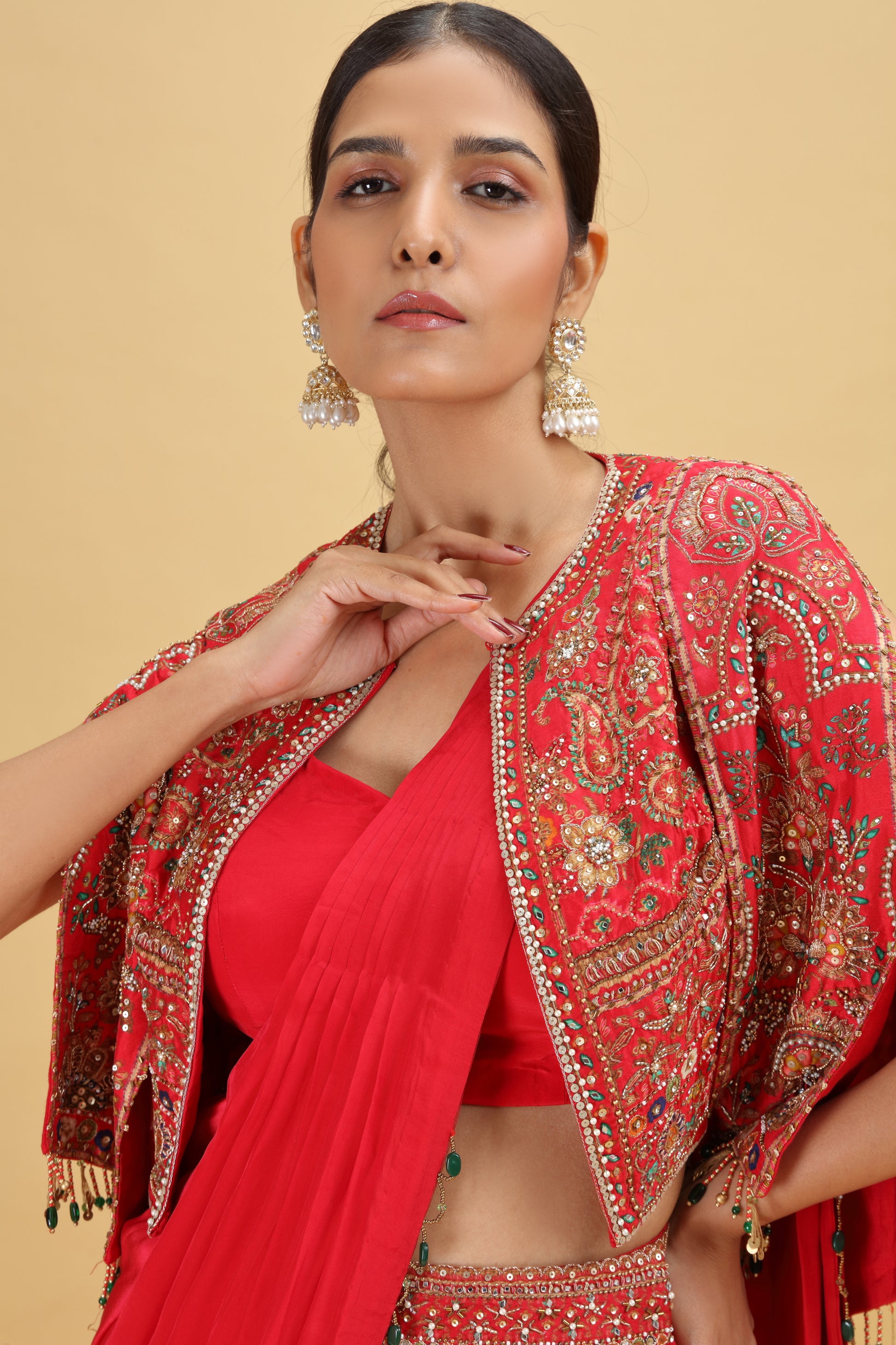Woman wearing a red saree with dola silk blouse with heavy work of Moti, Sequins, and Cutdana
