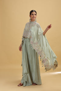 Woman wearing a light green salwar kameez suit with a floral dupatta