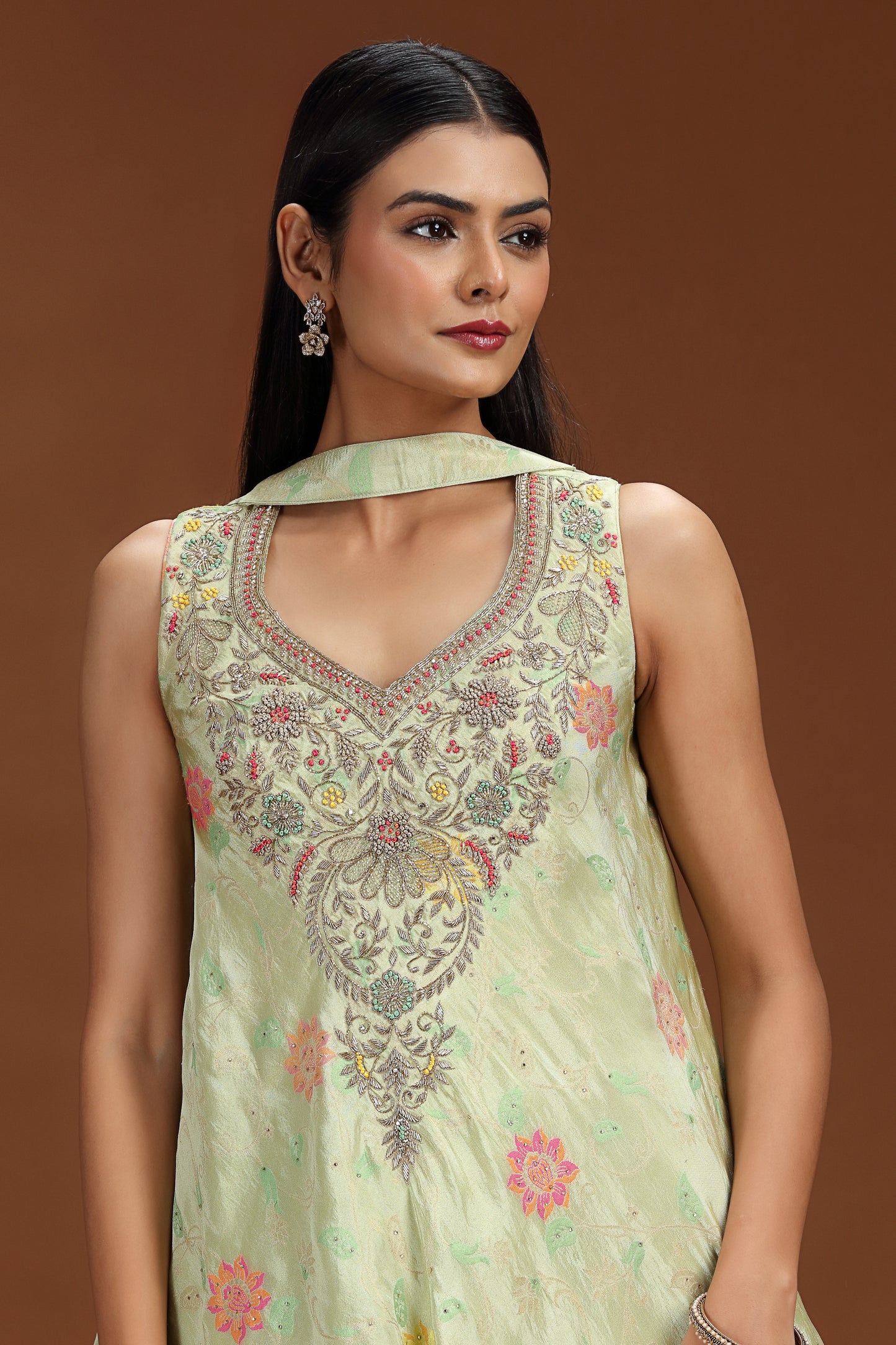 Woman wearing a light green embroidered salwar suit