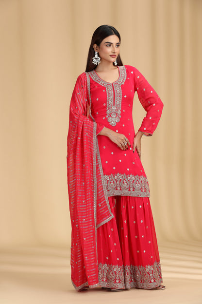 Woman wearing a rani color traditional outfit with silver embroidery on a beige background