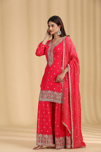 Woman wearing a pink traditional outfit with white patterns on a beige background