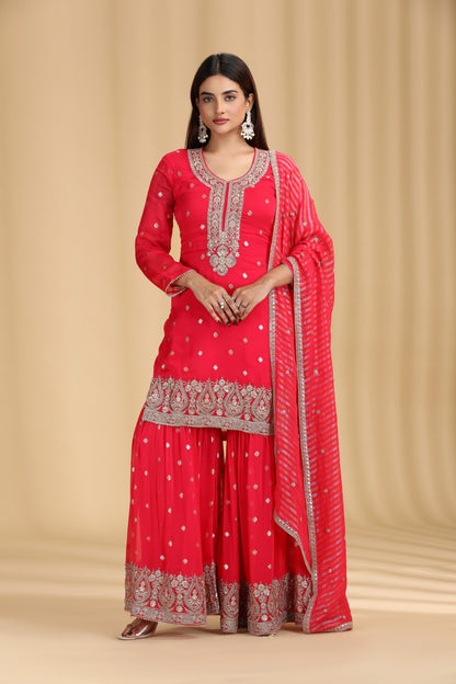 Woman wearing a rani pink salwar kameez  with intricate patterns on a beige background