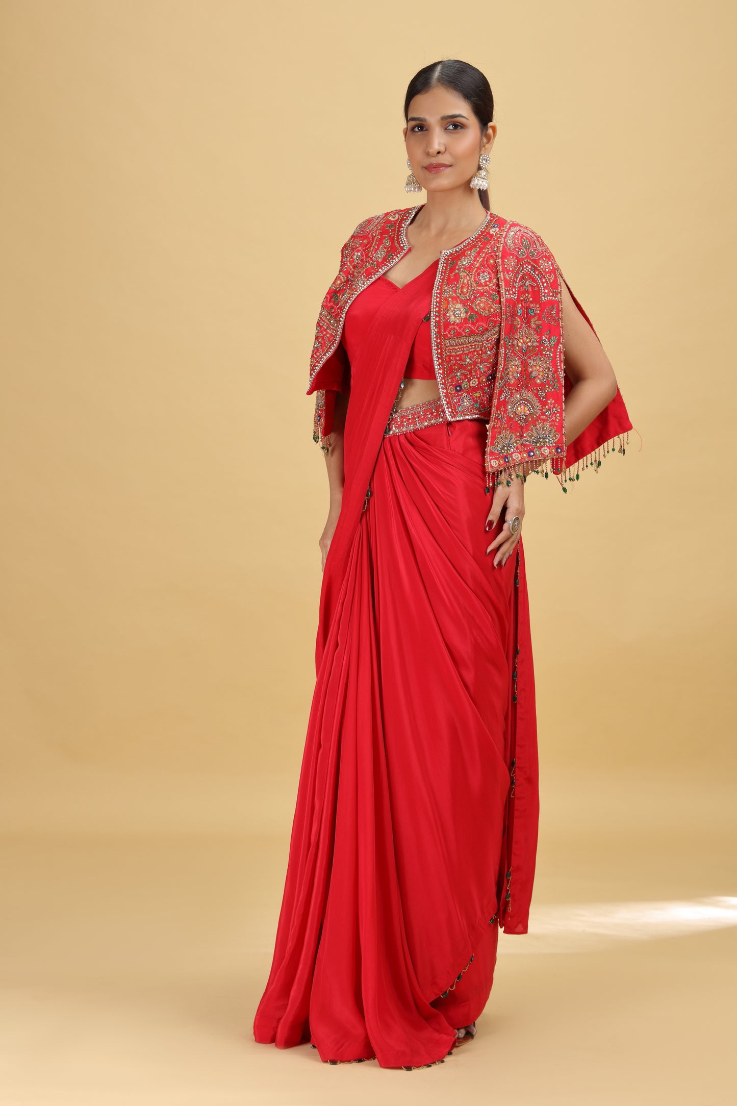 Woman wearing a designer red saree with a matching blouse